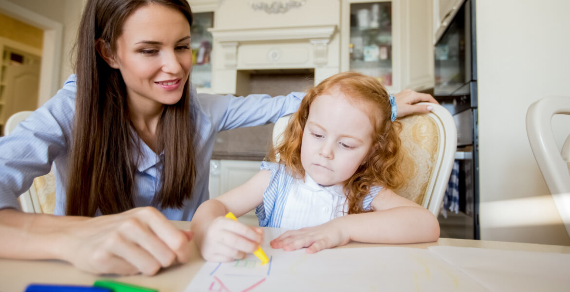 Happy mother or nanny looking at drawing girl